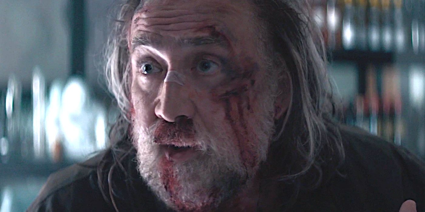 Nicolas Cage in Pig with scruffy long gray hair and beard, face covered in blood, looking distressed