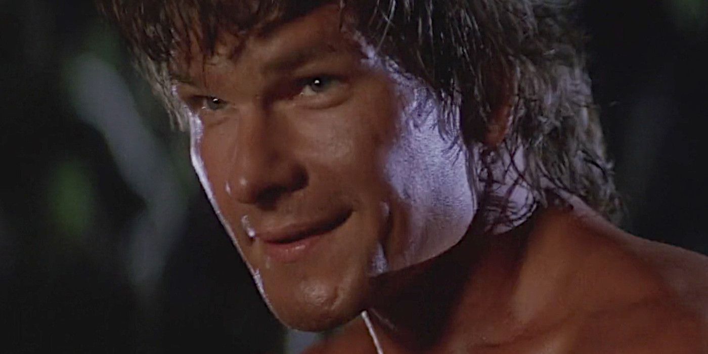Close-up of Patrick Swayze as Dalton in Road House in the middle of a fight, smiles.
