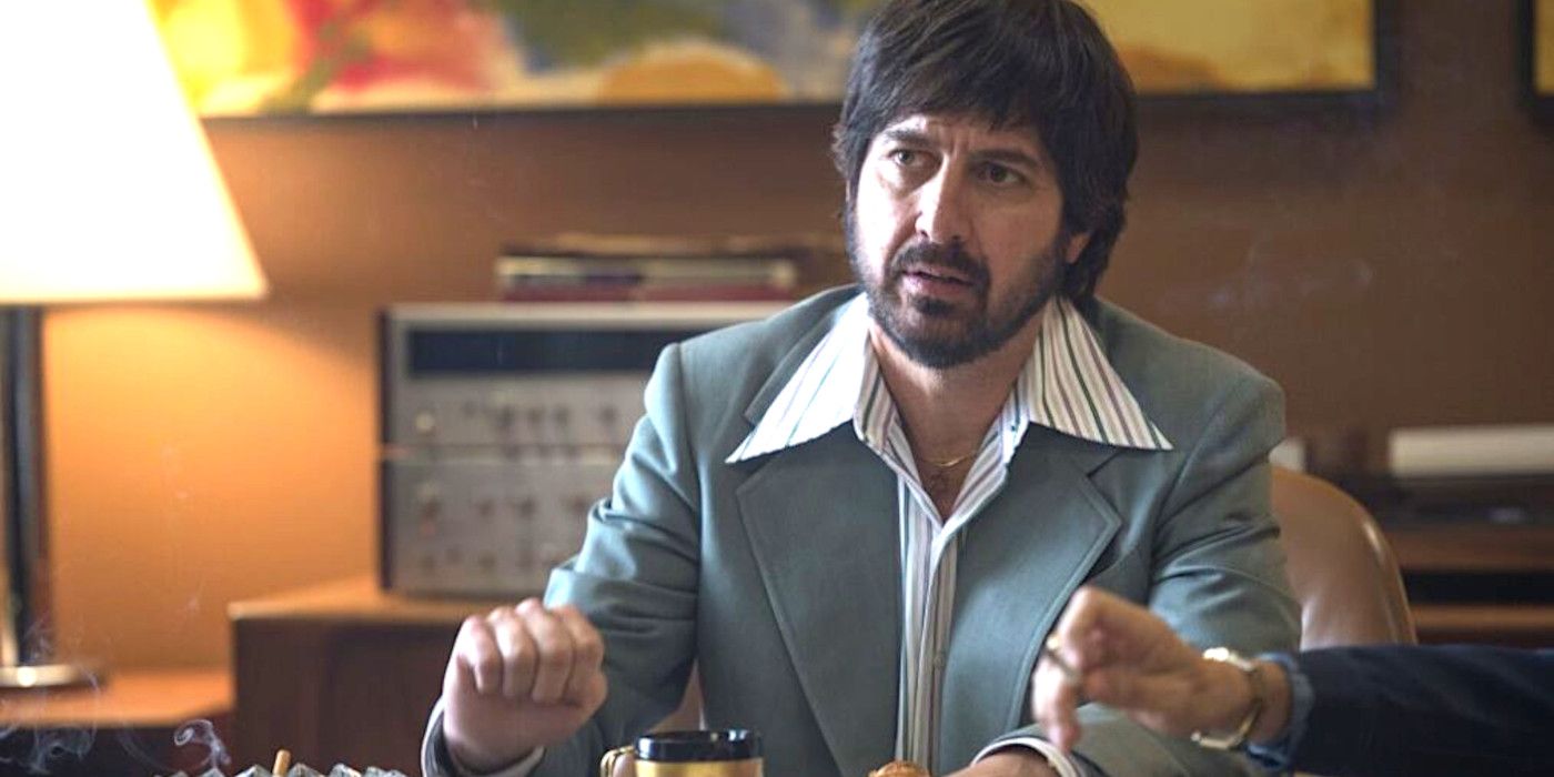 Ray Romano in Vinyl in a wide collared shirt and jacket, in a 1970s office, with a beard and 70s haircut