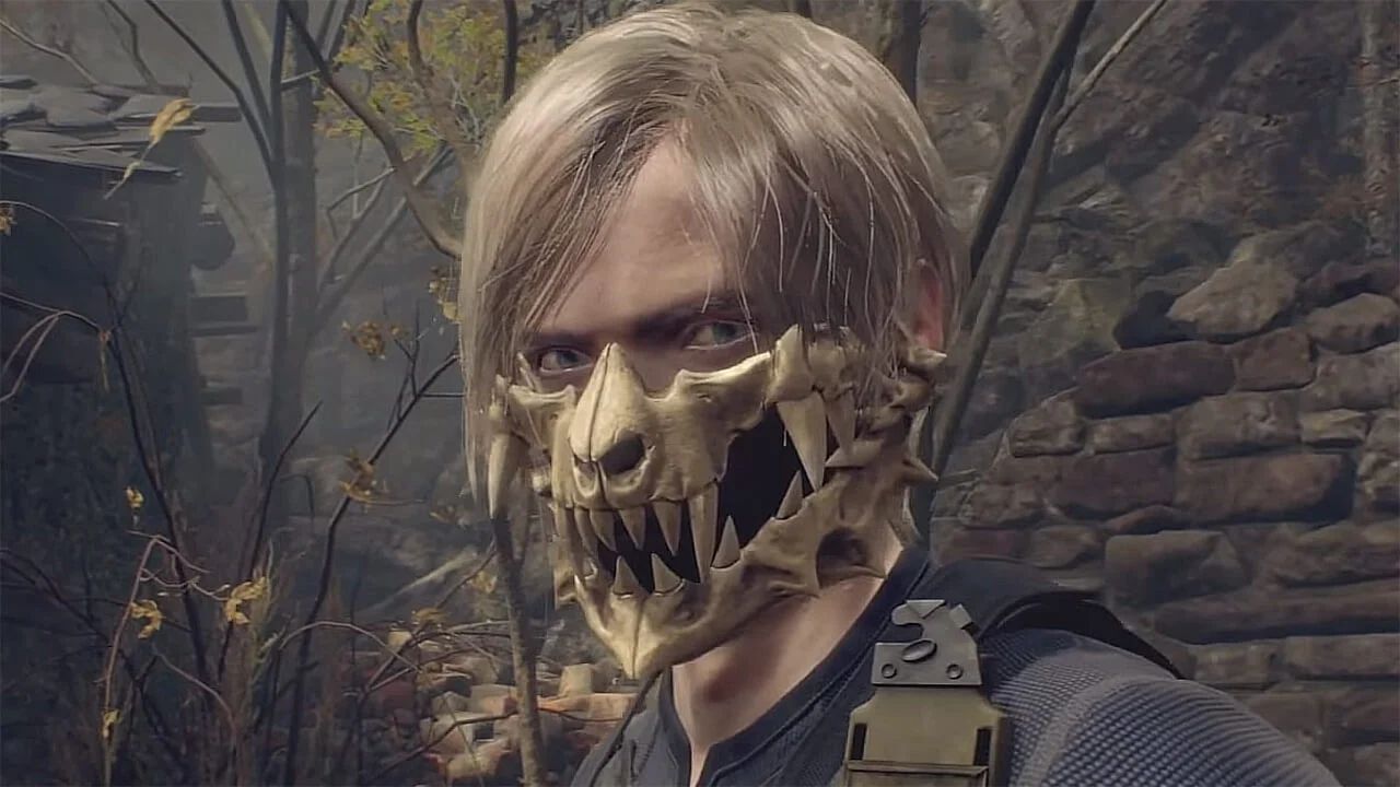 Resident Evil 4 Remake's Leon wears the Skull Mask accessory on his face. Behind him are trees and a brick wall.