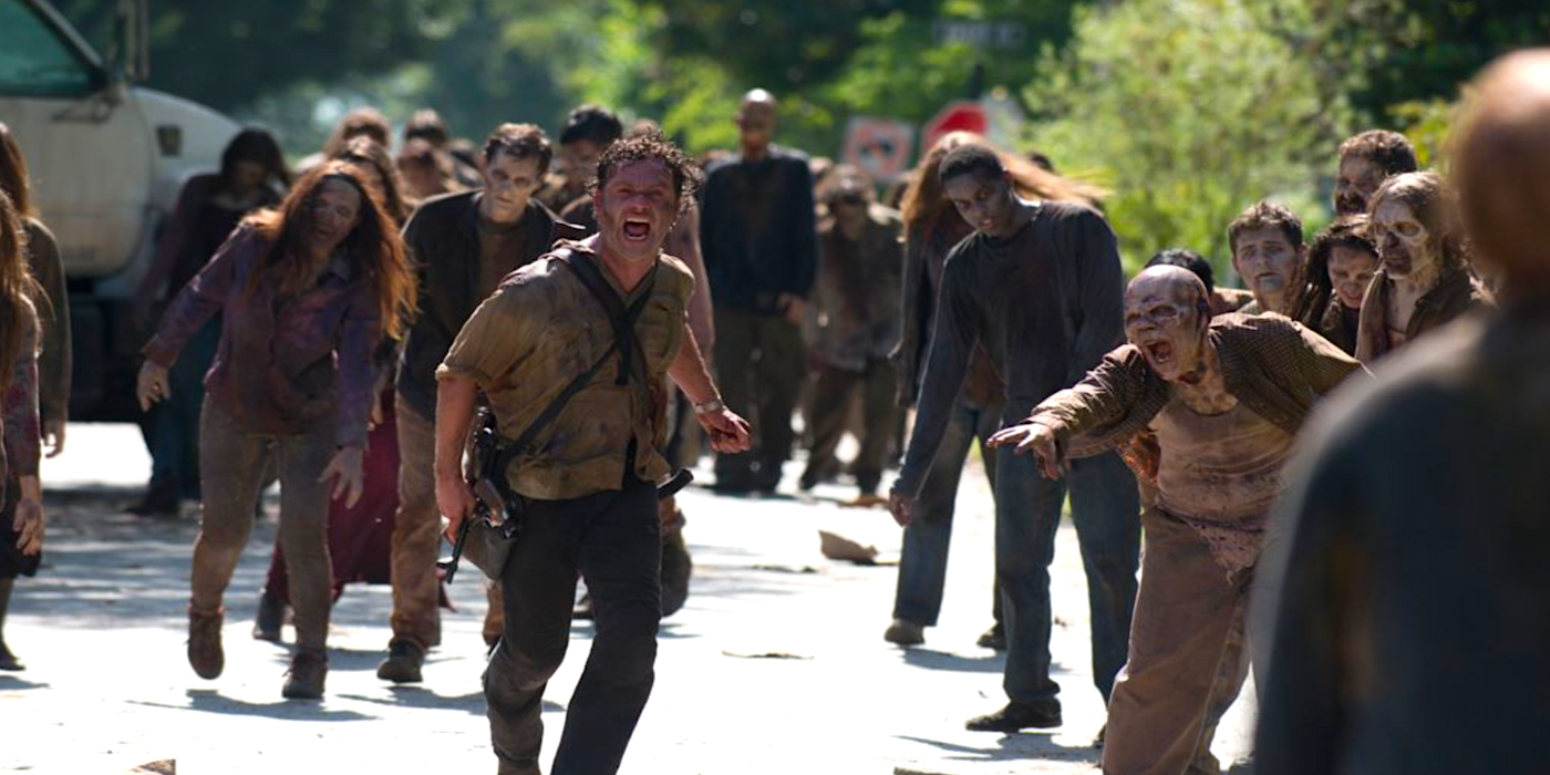 Andrew Lincoln as Rick running from zombies in The Walking Dead.