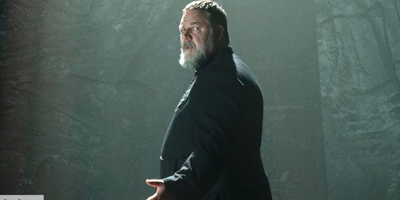 Russell Crowe as Father Amorth with his arm outstretched in The Pope's Exorcist
