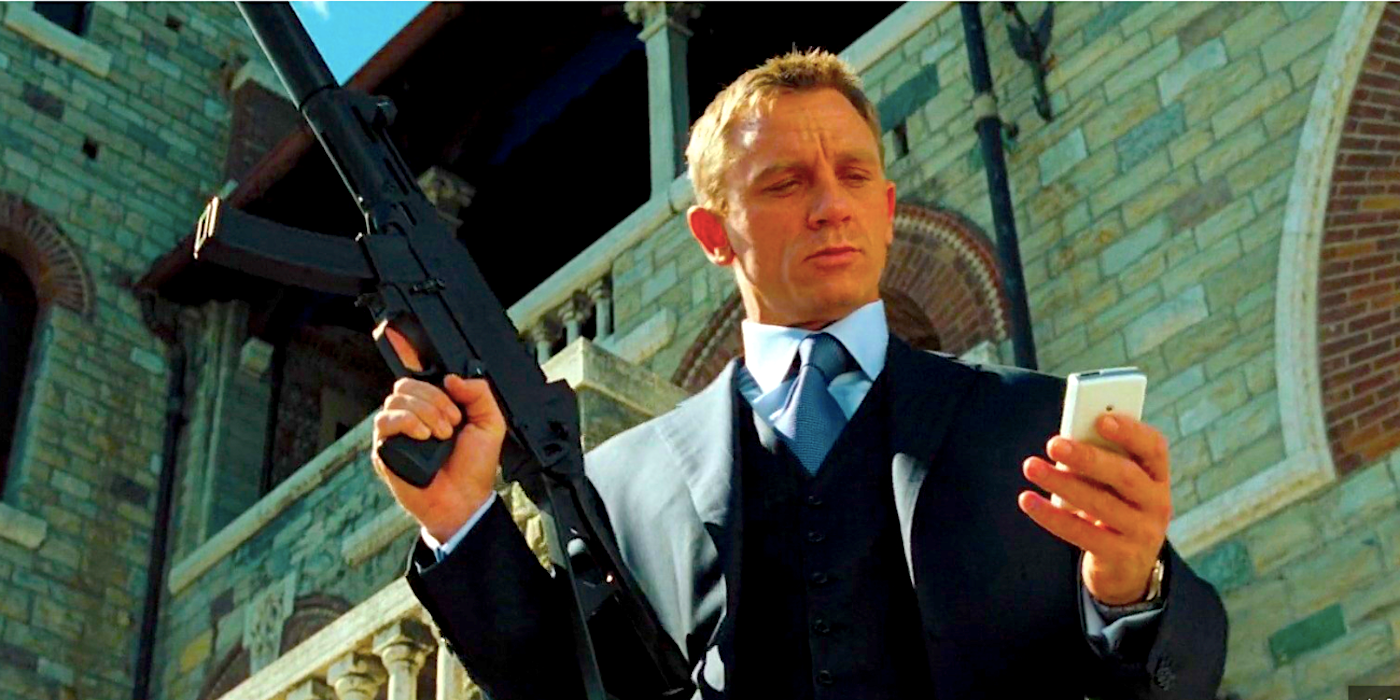 Daniel Craig como James Bond olhando para seu telefone enquanto segura sua arma no Casino Royale