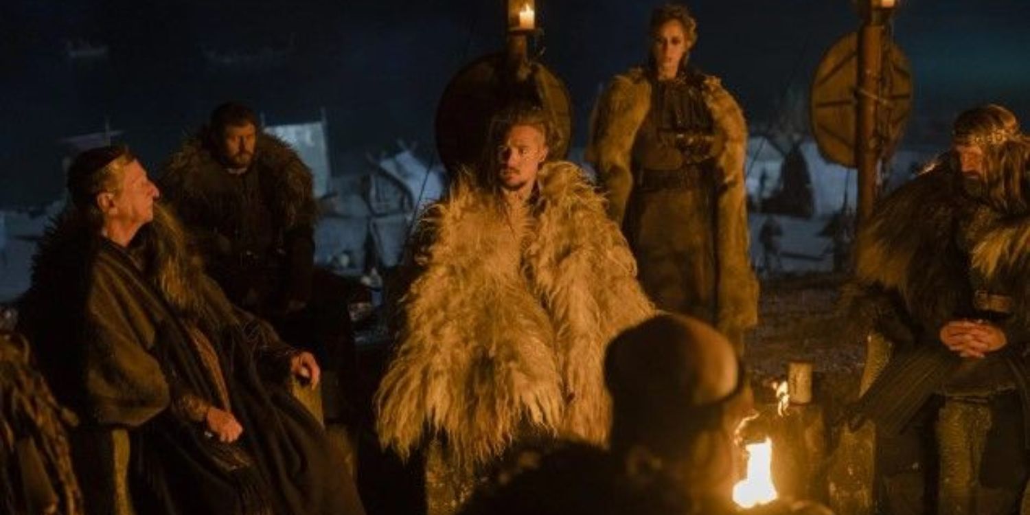 Several characters sitting around a fire with Uhtred in Seven Kings Must Die