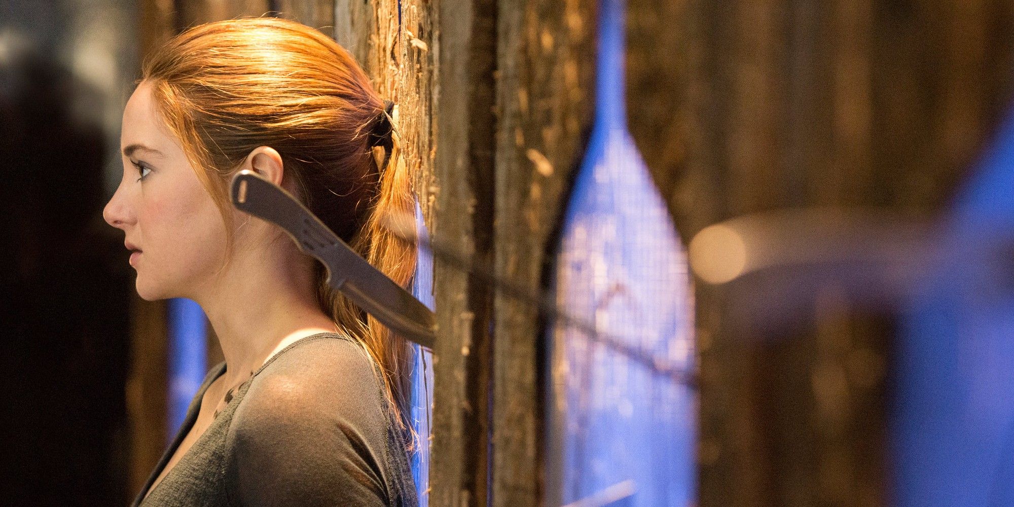 Shailene Woodley se estreitando e perdendo uma faca atirada nela em Divergente