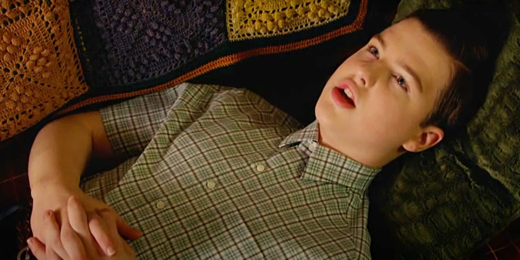 Sheldon laying on the couch in Young Sheldon season 6