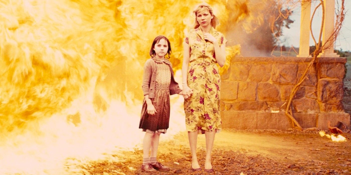 Michelle Williams holding hands with a young girl while surrounded by fire in Shutter Island