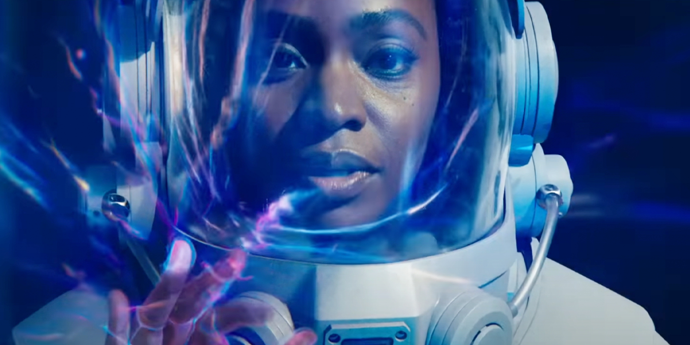 Monica Rambeau in an astronaut suit, touching an anomaly in space in The Marvels.
