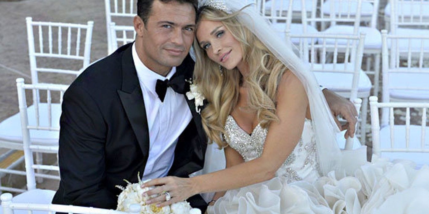 Joanna Krupa and Romain Zago sit closely together after their wedding ceremony.