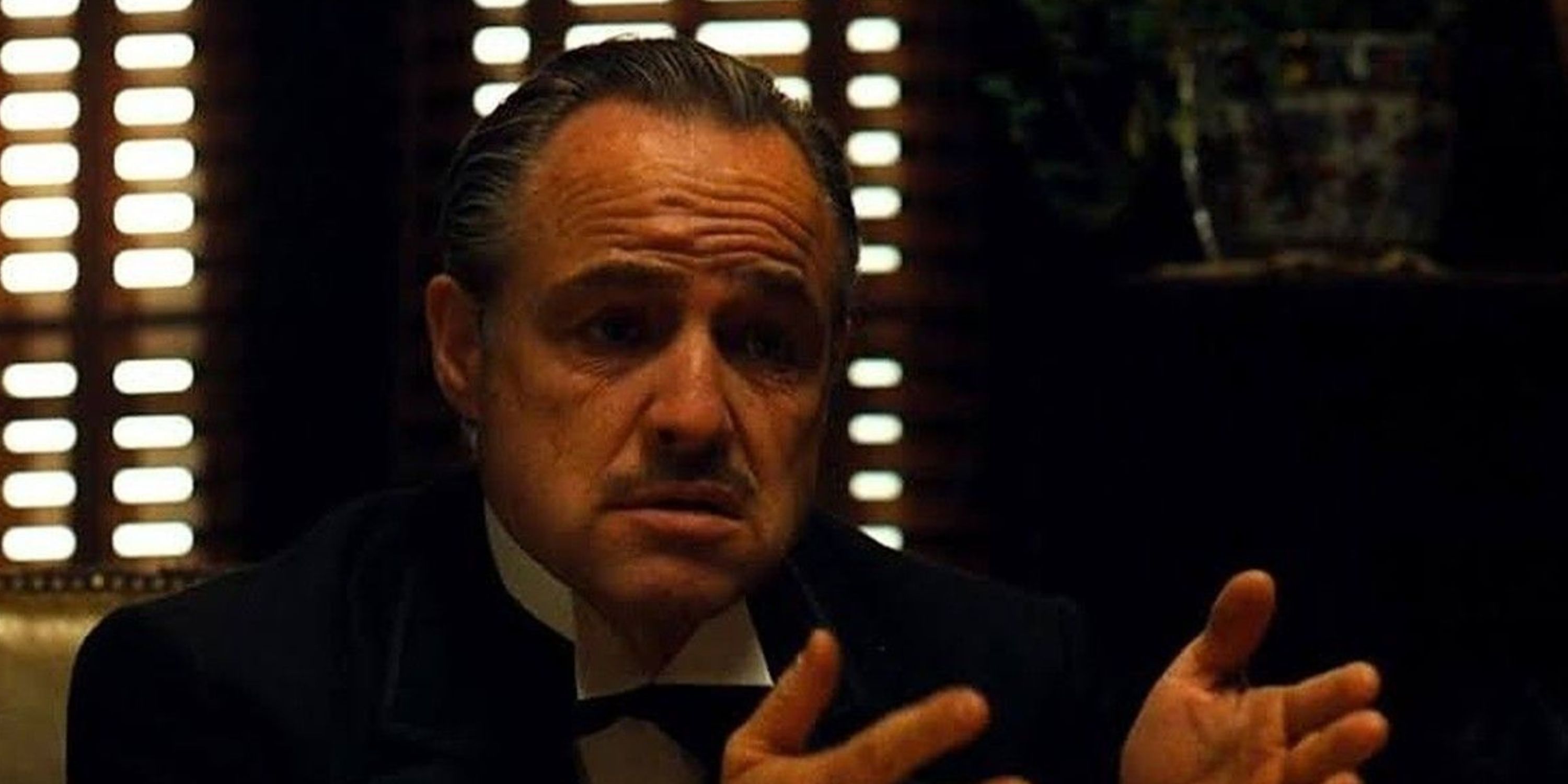 Vito Corleone sentado em sua mesa em O Poderoso Chefão
