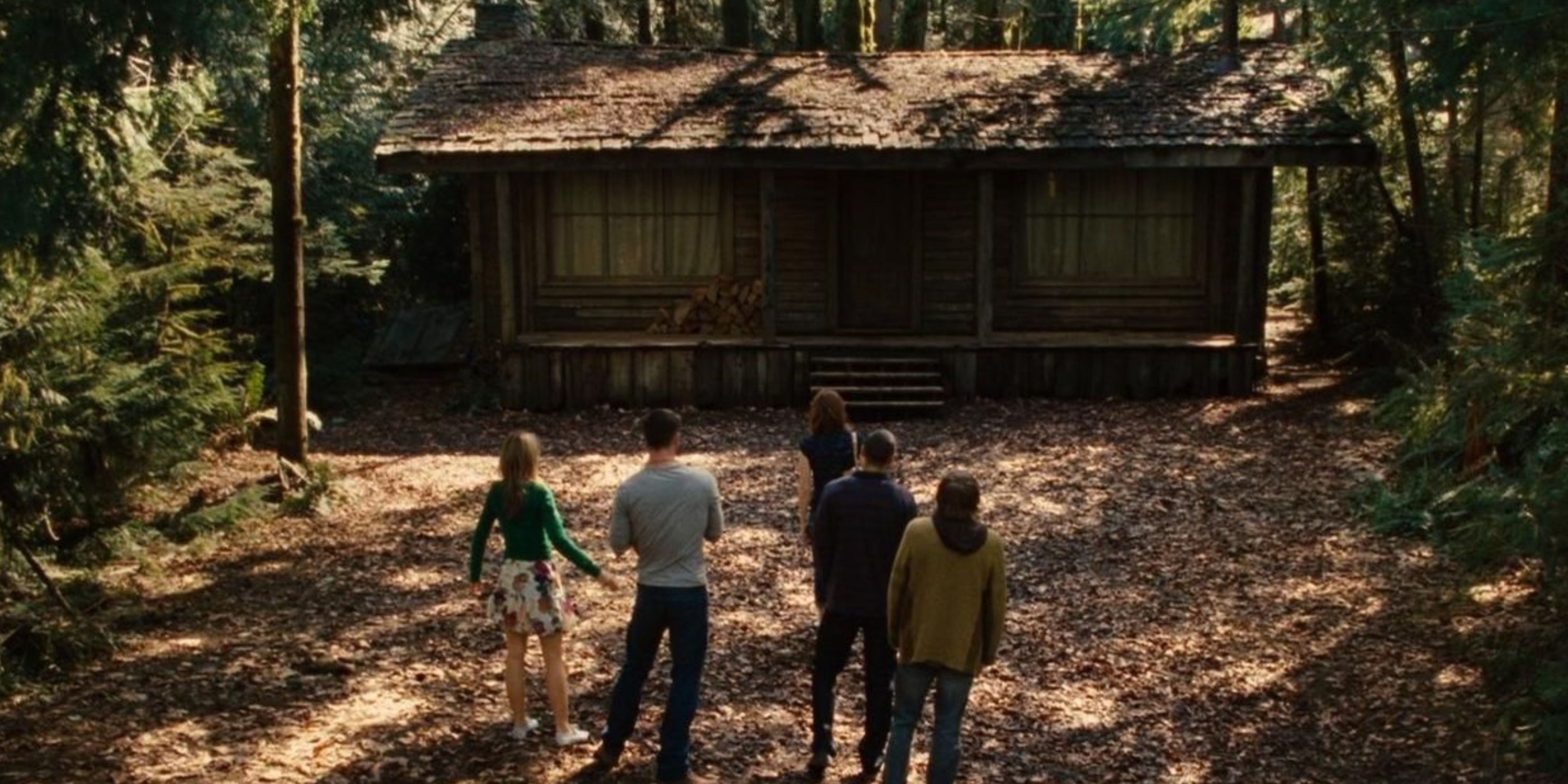 The main characters of The Cabin in the Woods standing outside the cabin and looking at it