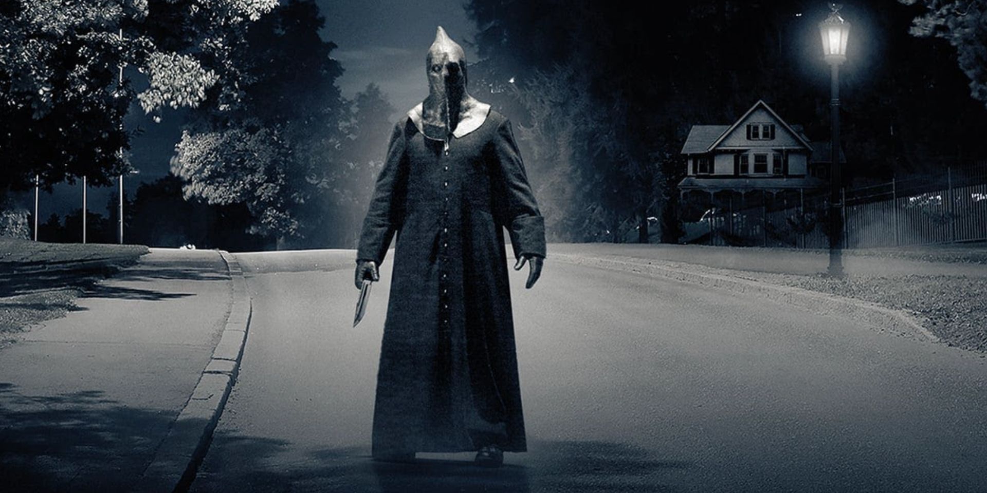 A masked figure holding a knife in the middle of a deserted street in Slasher