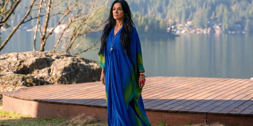 Adult Lottie (Simone Kessell) in Yellowjackets season 2 episode 6 standing by the lake.