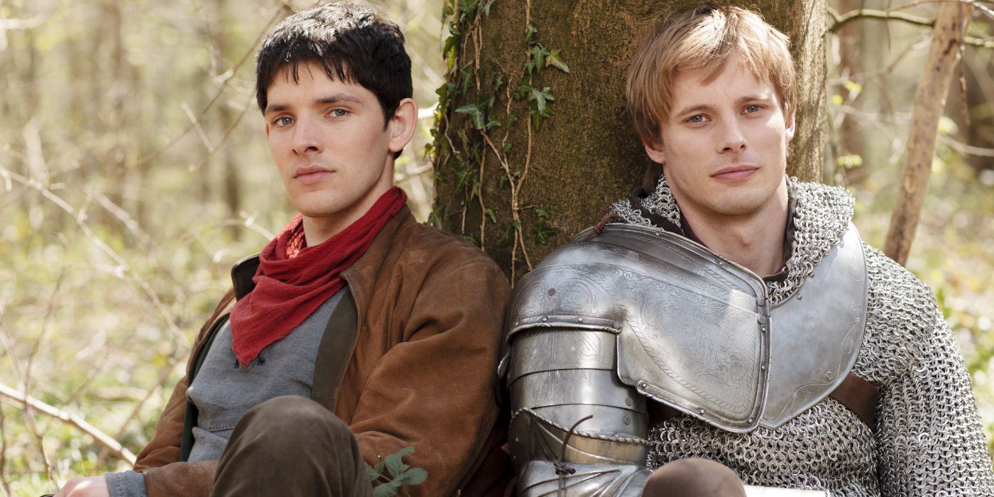 Arthur and Merlin sitting with their backs against a tree in Merlin
