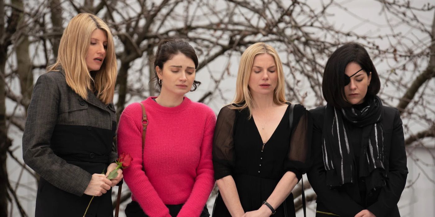 Sisters stand at a grave side looking sad in Bad Sisters season 1