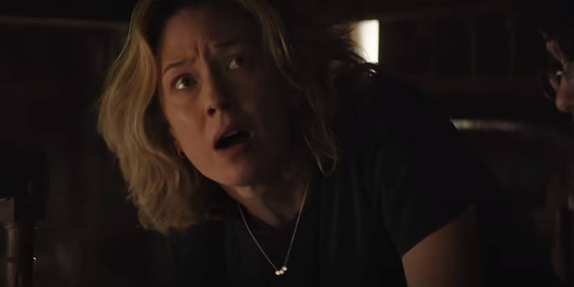 Carrie Coon hiding under a table in Ghostbusters Afterlife