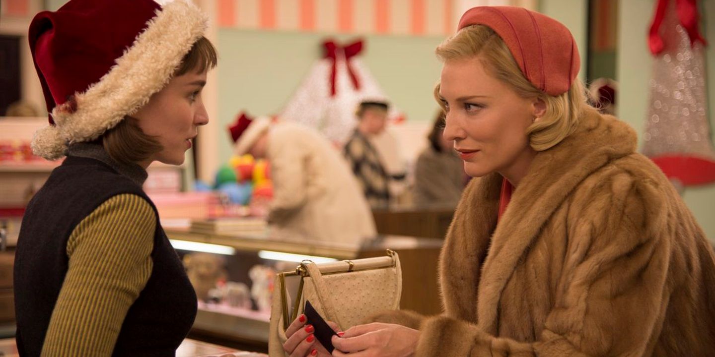 Cate Blanchett's Carol (in fur coat) talks to Rooney Mara as Therese (in Santa hat) at the department store counter in Carol