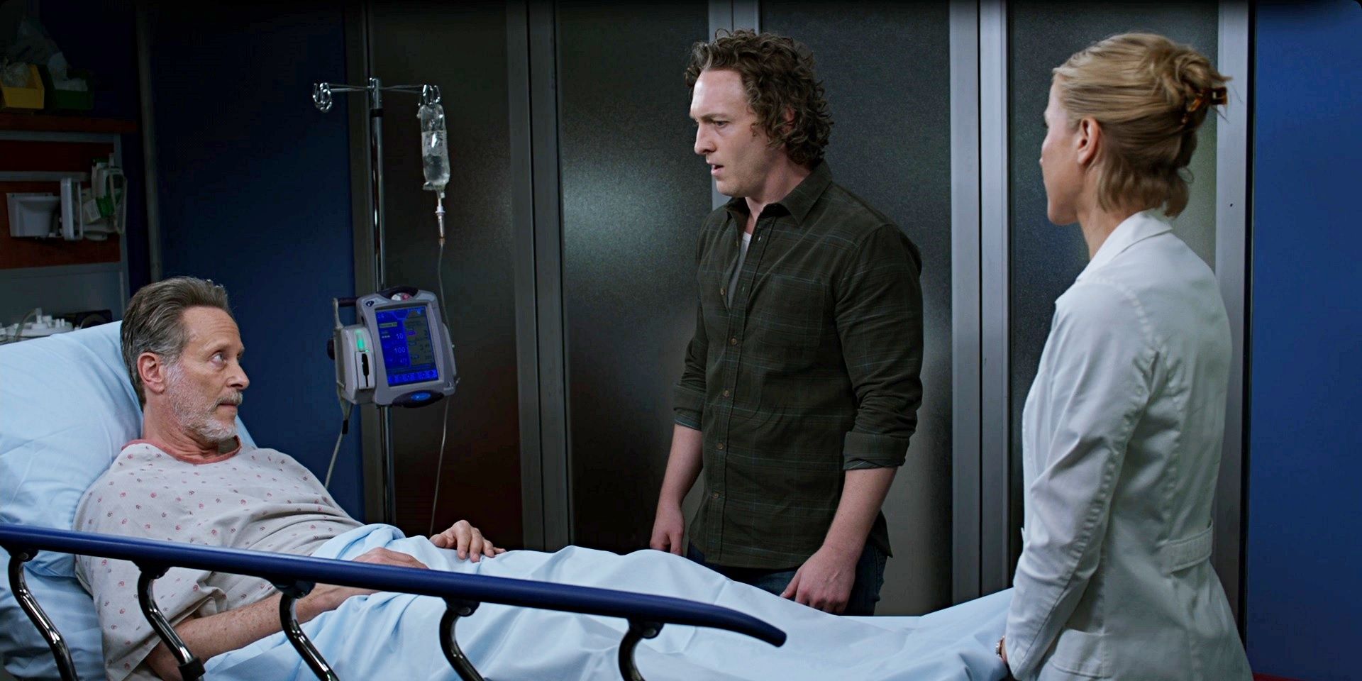 Sean and Asher stand next to Archer's hospital bed in the Chicago Med season 8 finale.