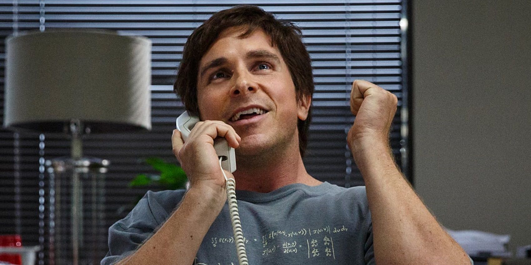 Christian Bale on the phone looking excited in The Big Short