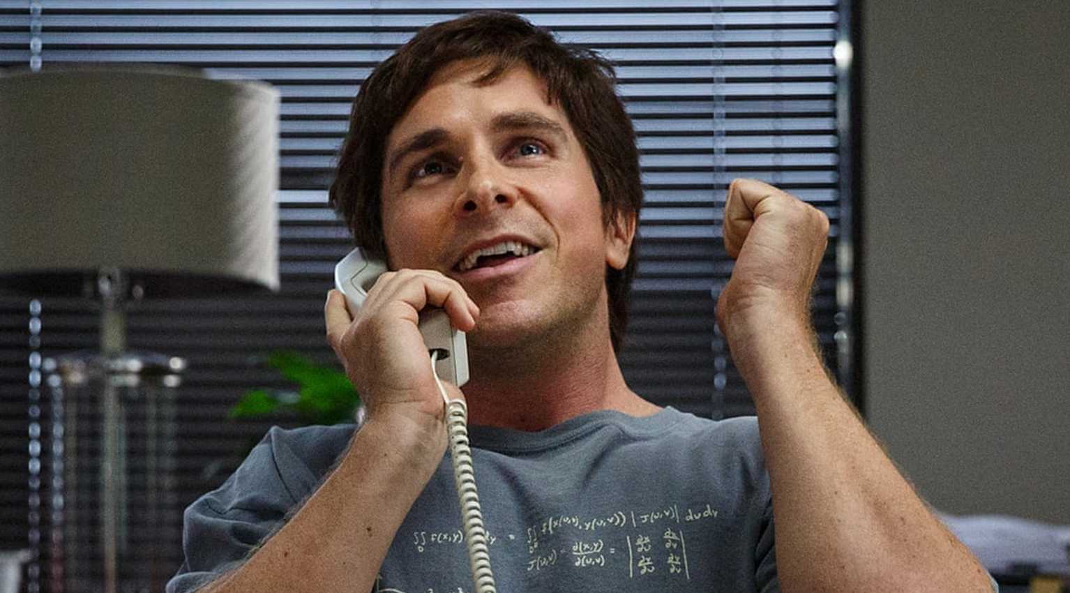 Christian Bale as Michael Burry on the phone looking excited in The Big Short