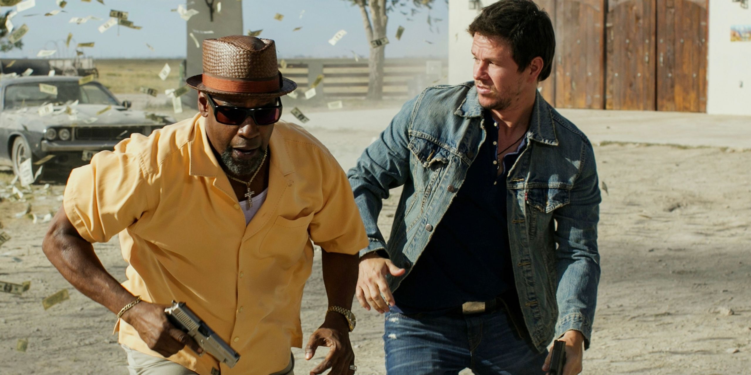 Denzel Washington and Mark Wahlberg running with guns in their hands and money flying behind them in the movie 2 Guns