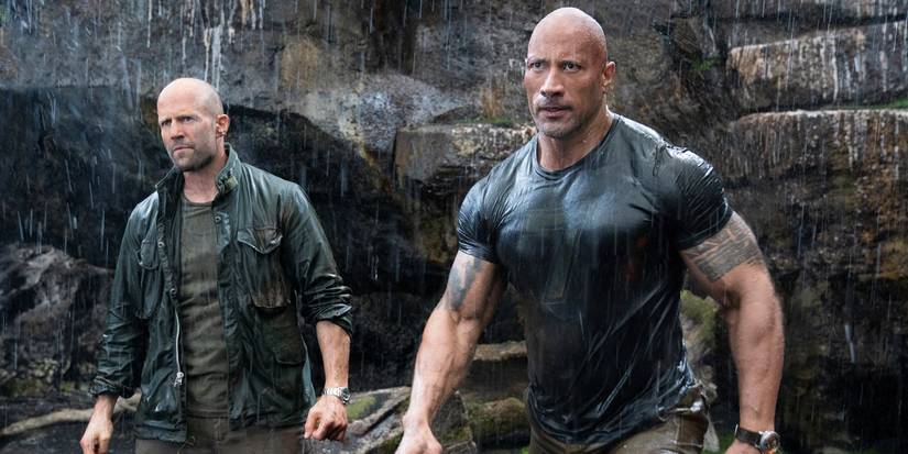 Dwayne Johnson as Luke Hobbs and Jason Statham as Deckard Shaw standing in the rain in Hobbs and Shaw