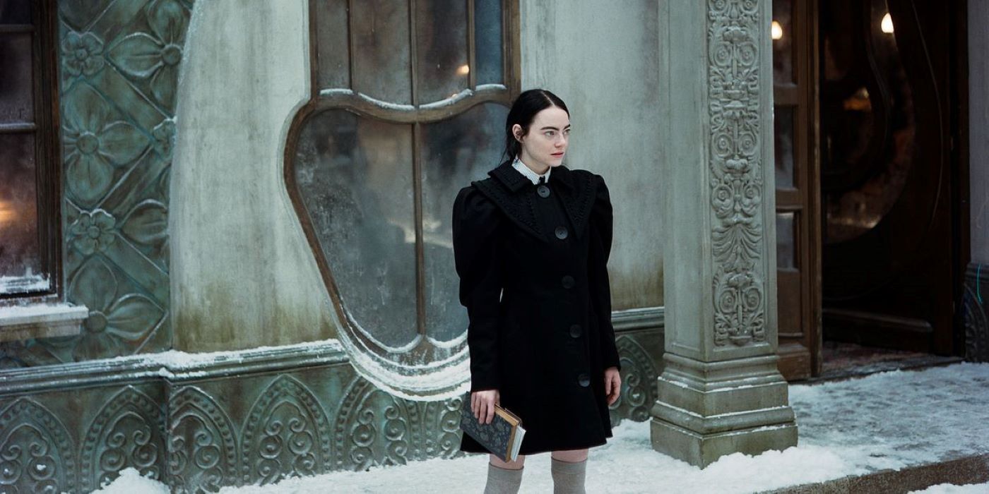 Emma Stone in black in the snow in Poor Things.