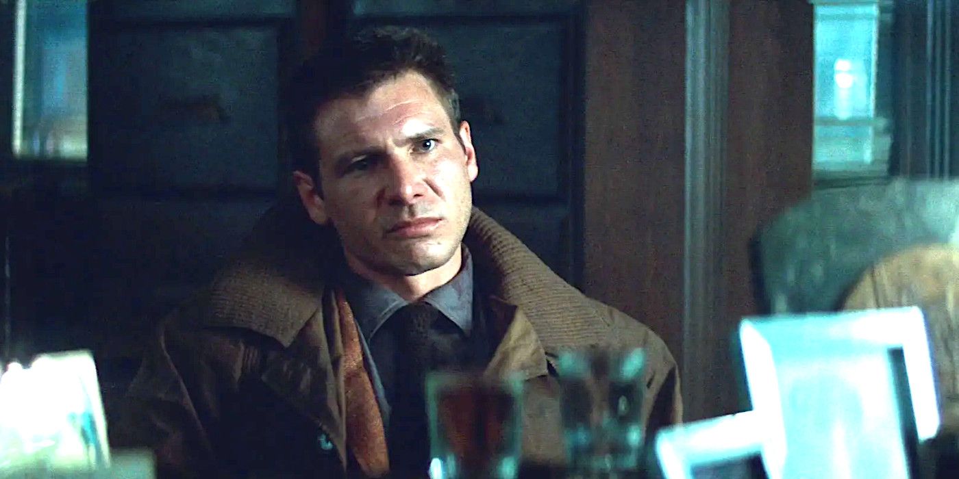 Harrison Ford como Deckard en Blade Runner sentado en una oficina sucia mirando a través de un escritorio con una expresión ligeramente desdeñosa.