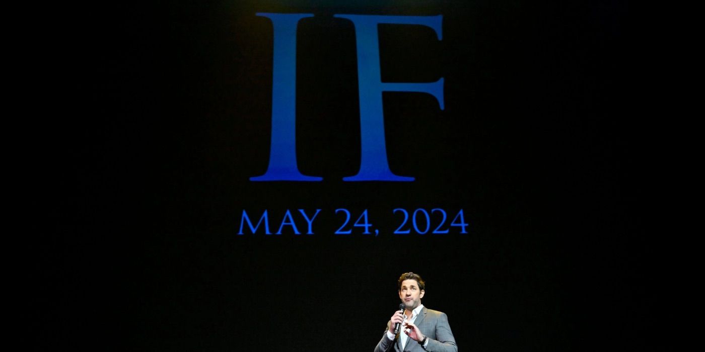 John Krasinski se tient devant un grand écran annonçant la date de sortie de IF.