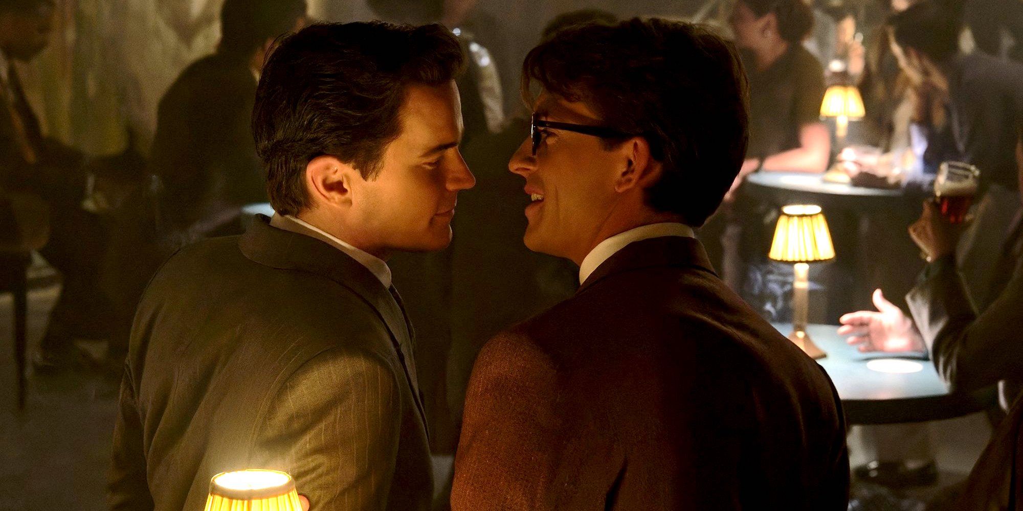 Jonathan Bailey and Matt Bomer About to Kiss at a table in Fellow Travelers