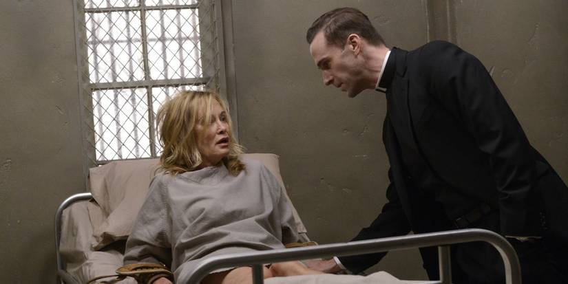 Joseph Fiennes leaning over Jessica Lange in a hospital bed in American Horror Story: Asylum