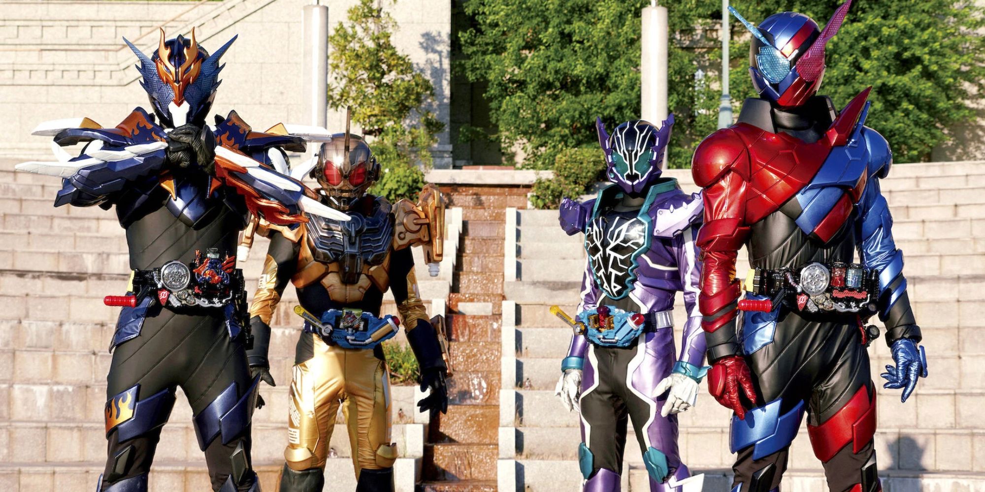 The Kamen RIders of Kamen RIder Build in their black, gold, purple, and red and blue suits on the steps to a building