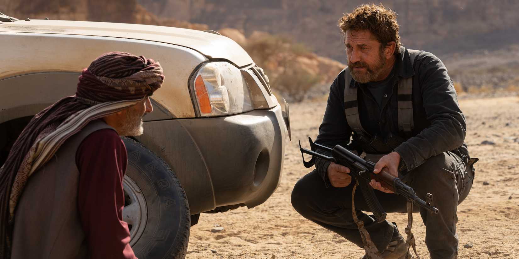 Gerard Butler holding a rifle as Harris and Navid Negahban as Mo in Kandahar