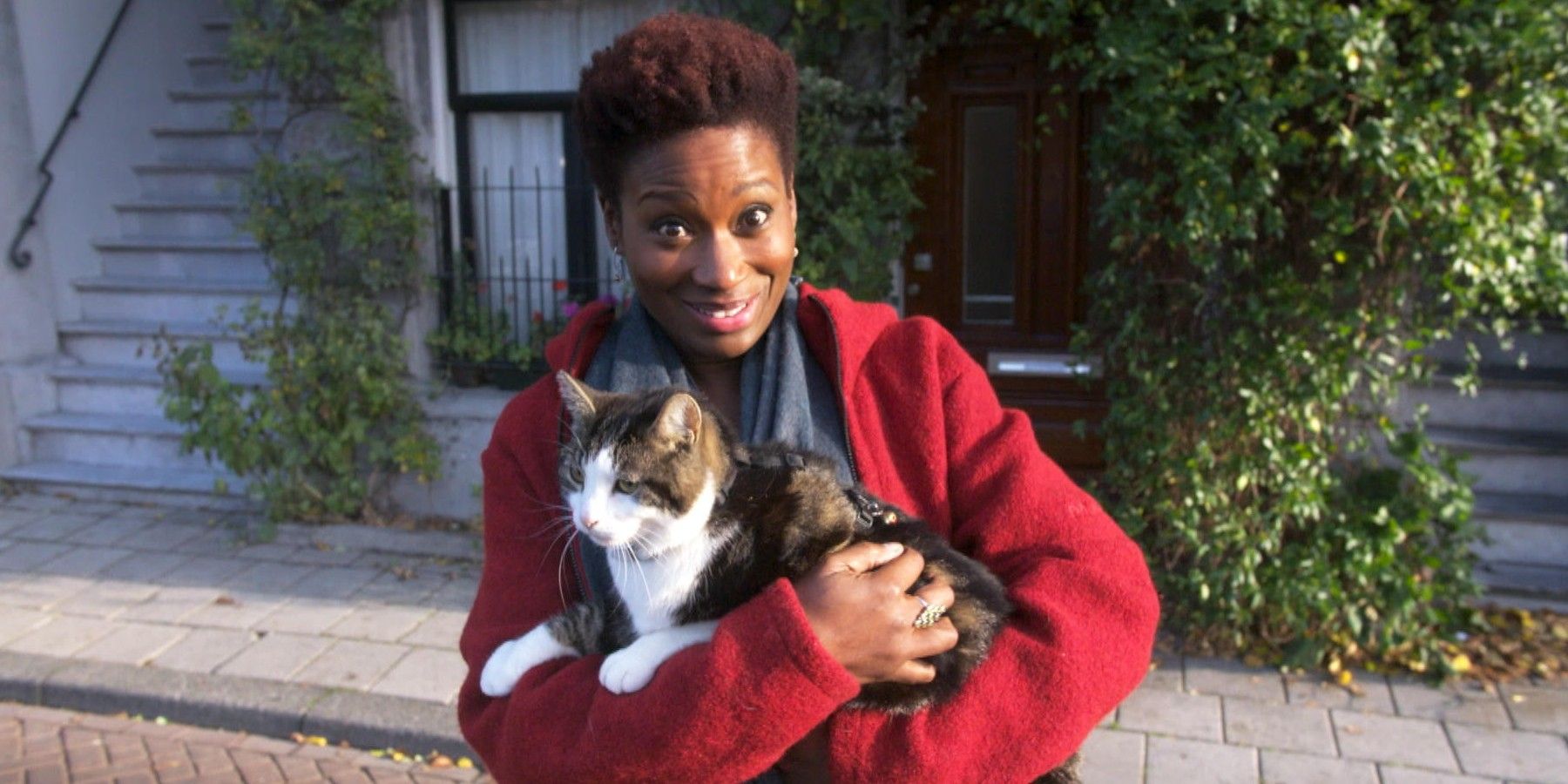 Una mujer sonriendo mientras sostiene un gato en Kitty Love: An Homage to Cats