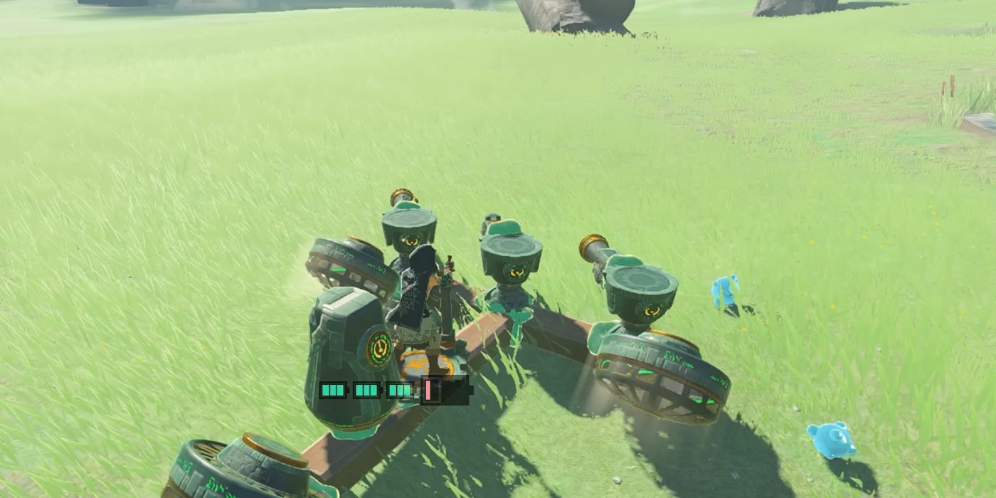 Link standing on top of a Fan-powered machine, steering it using the Steering Stick in Tears of the Kingdom.