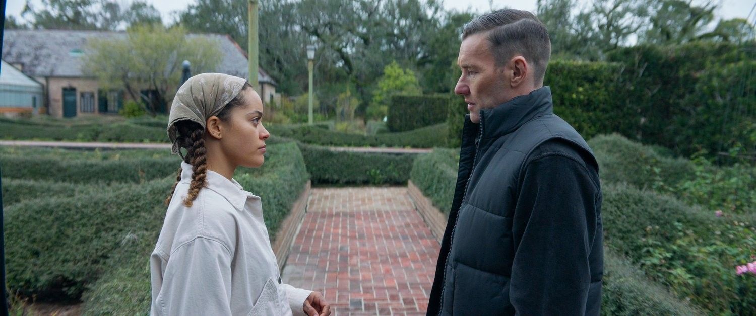 Master Gardener confrontation between Quintessa Swindell and Joel Edgerton's characters surrounded by hedges.