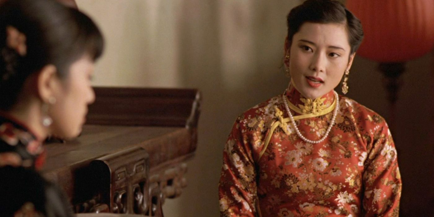 Songlian sits in a red Chinese qipao in the film Raise the Red Lantern