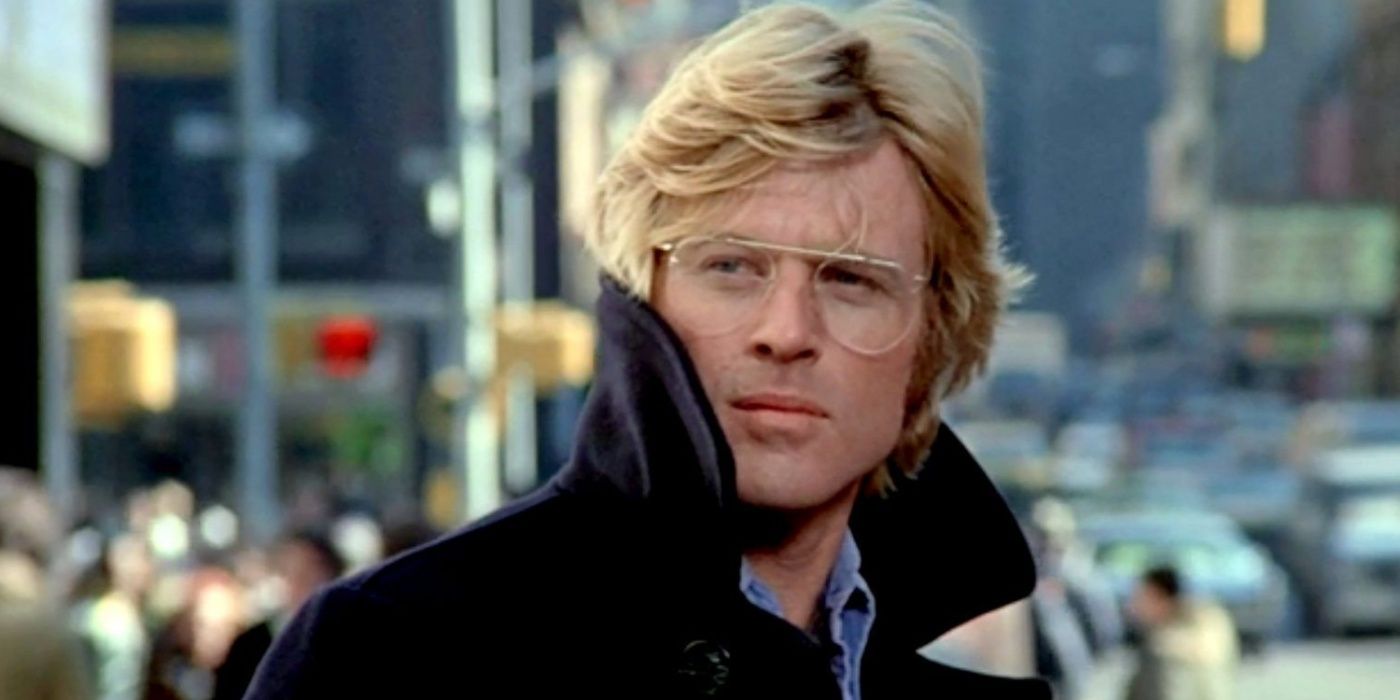 Robert Redford wearing a coat and glasses in Three Days of the Condor