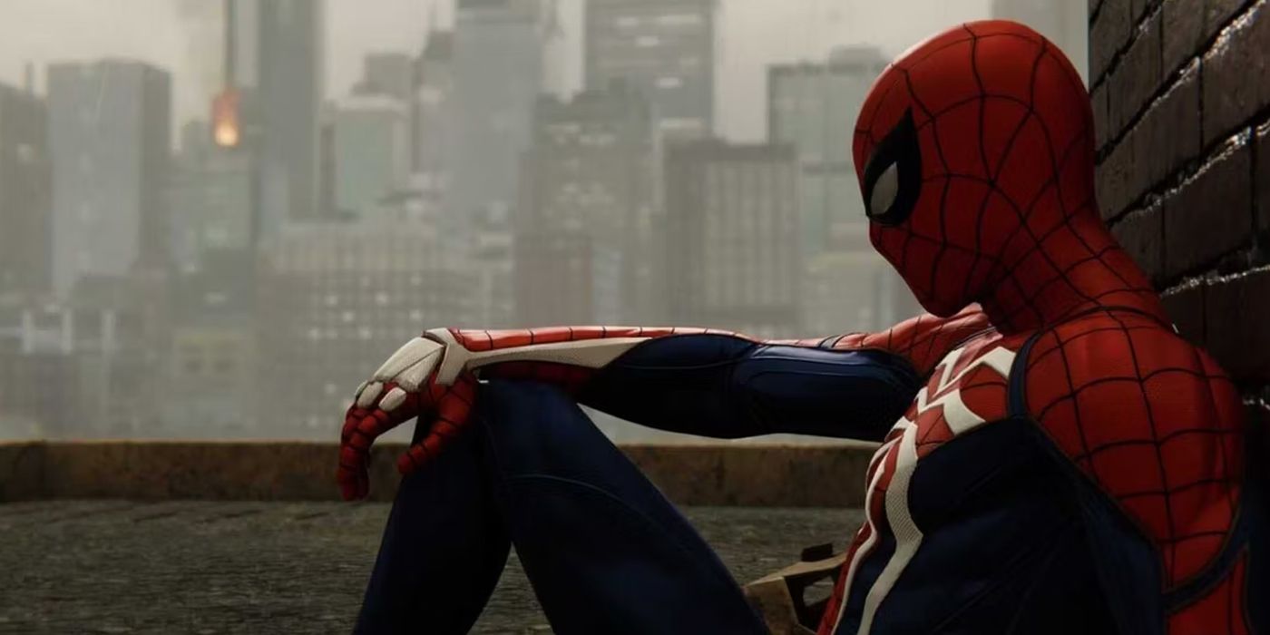 Spider-Man sits against a wall on a rooftop looking sad in Marvel's Spider-Man