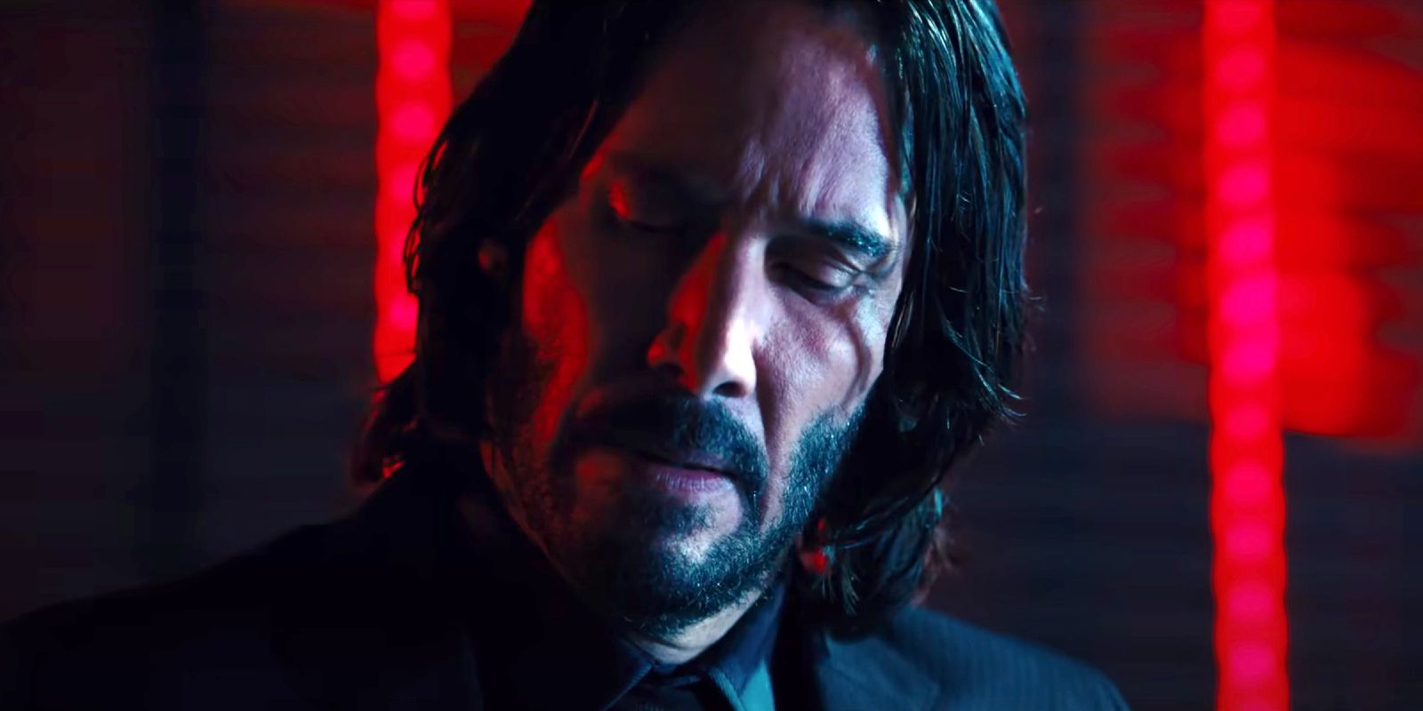 Keanu Reeves as John Wick looking down and off to the side in John Wick Chapter 4