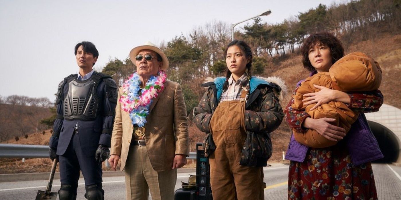 The cast of The Odd Family standing on a road