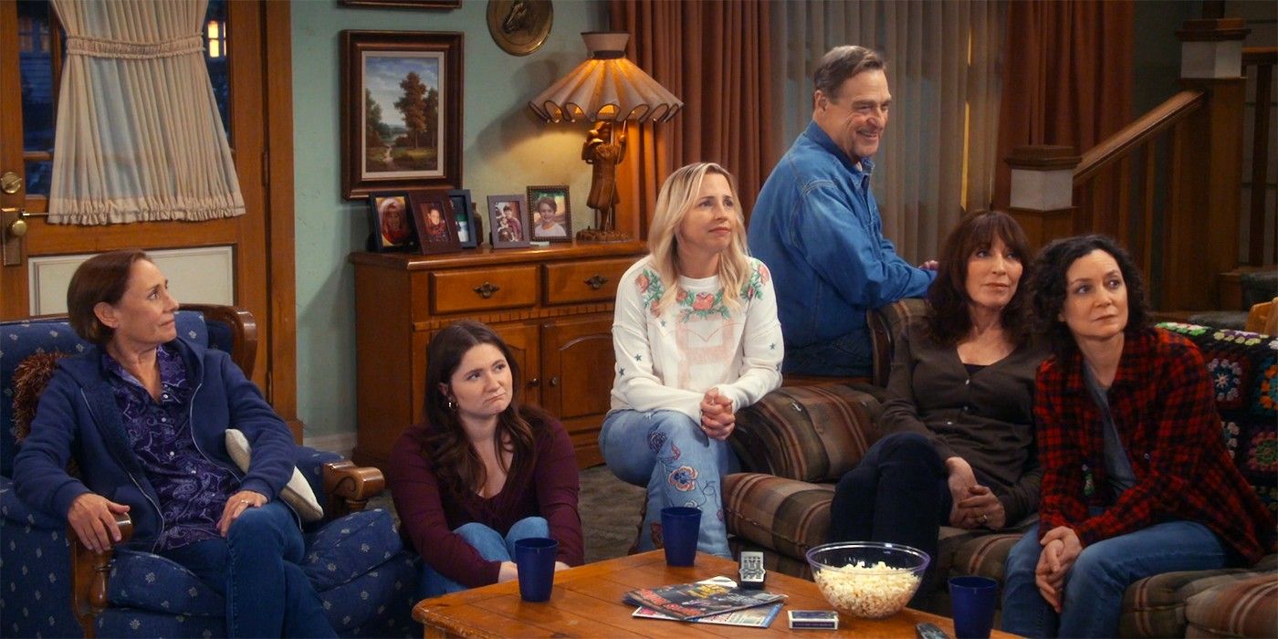 A família Conners sentada ao redor do sofá em uma cabana na comédia