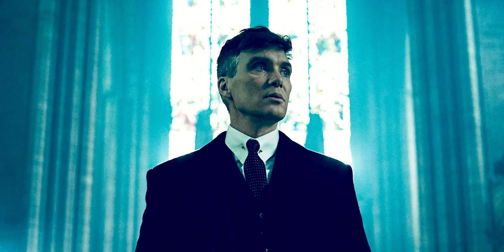 Cillian Murphy as Tommy Shelby looking to the side while standing in a church in Peaky Blinders