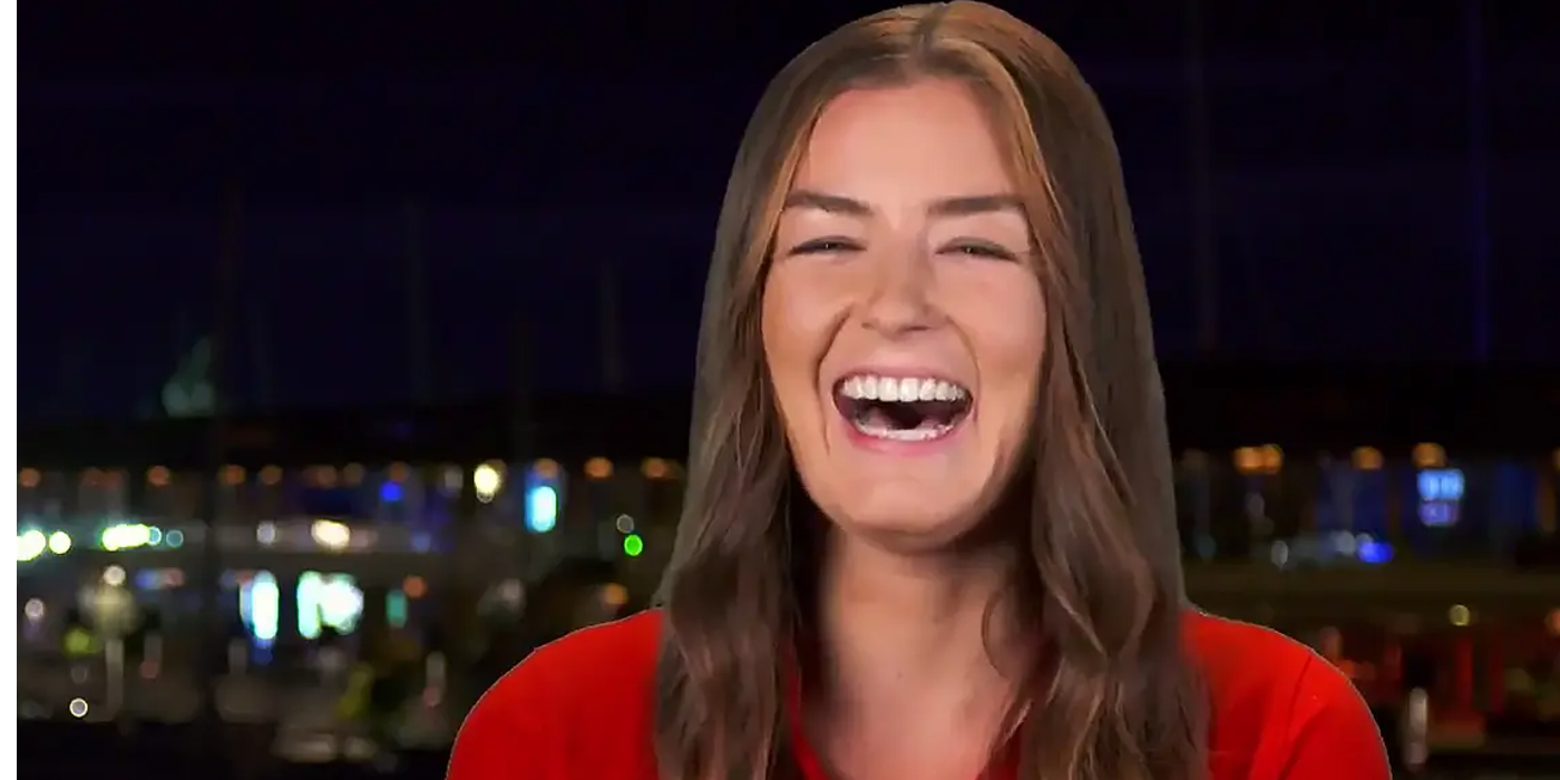 Below Deck's Aesha Scott laughing at the camera during her early seasons in a red uniform