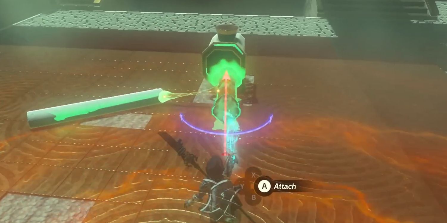 Link plants a green-glowing stake into a device in Tears of the Kingdom using the Ultrahand ability. An on-screen prompt directs the player to press A to attach the two parts.