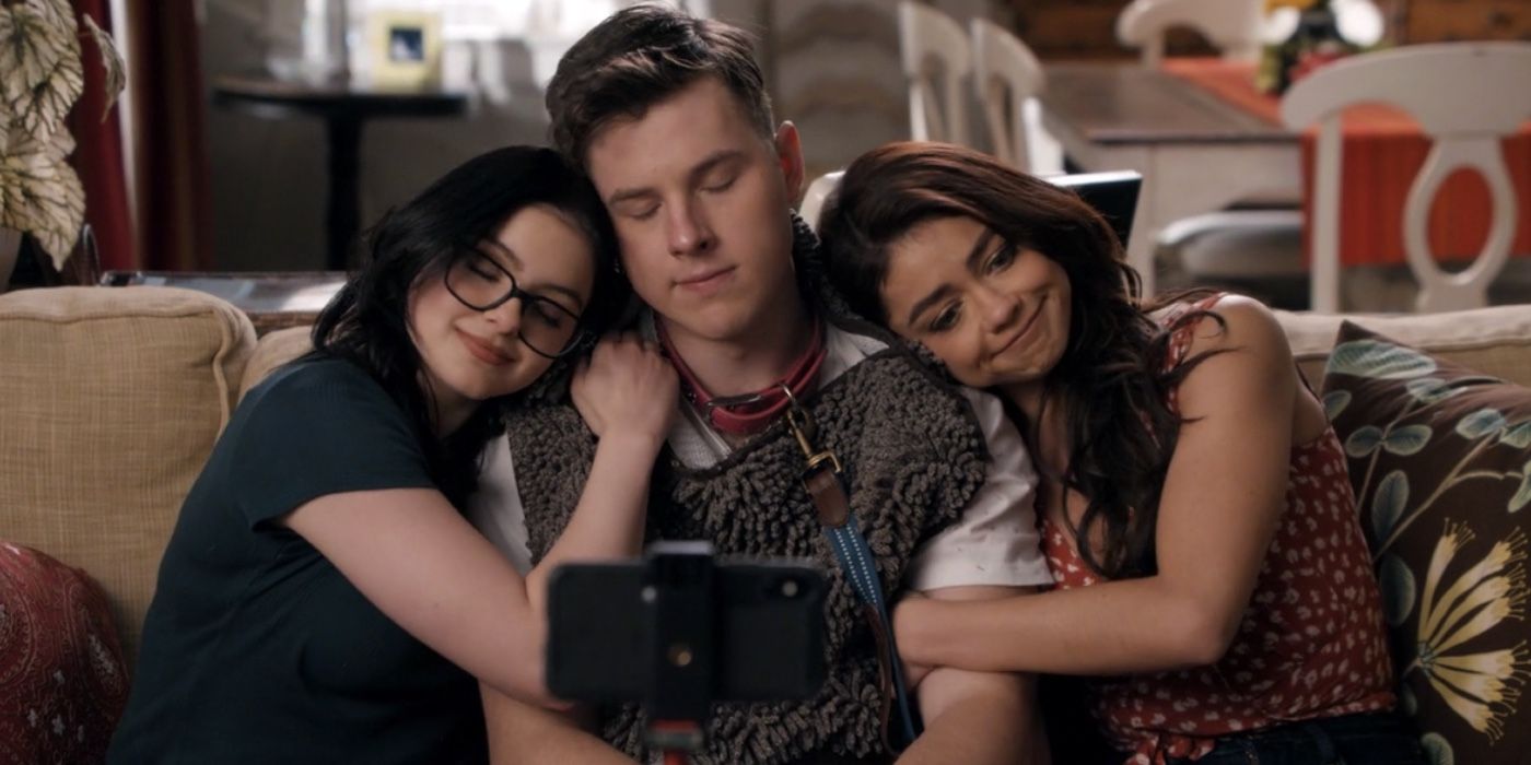 Alex Luke and Haley hug on the couch in Modern Family