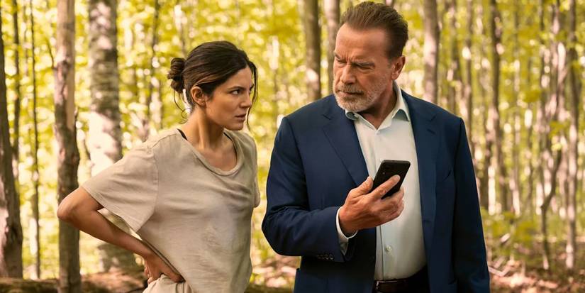 Luke and Emma look annoyed at each other while looking at a phone in the woods in FUBAR