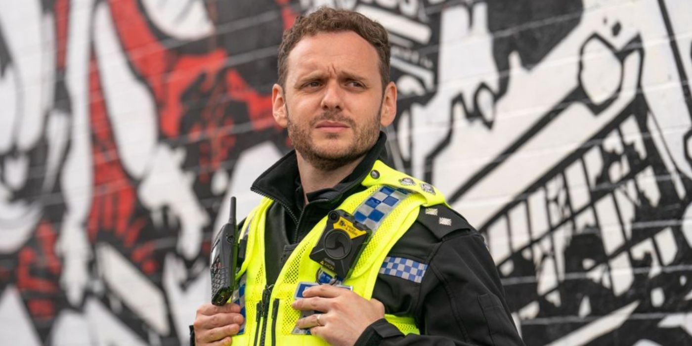 Nathan stands in front of a wall of graffiti in The Full Monty 2023