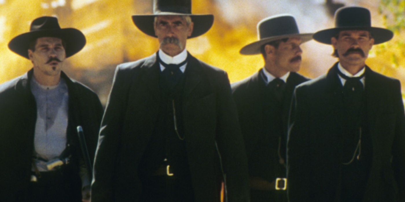 Val Kilmer as Doc Holliday, Sam Elliott as Virgil Earp, Bill Paxton as Morgan Earp, and Kurt Russell as Wyatt Earp walking away from an explosion in Tombstone