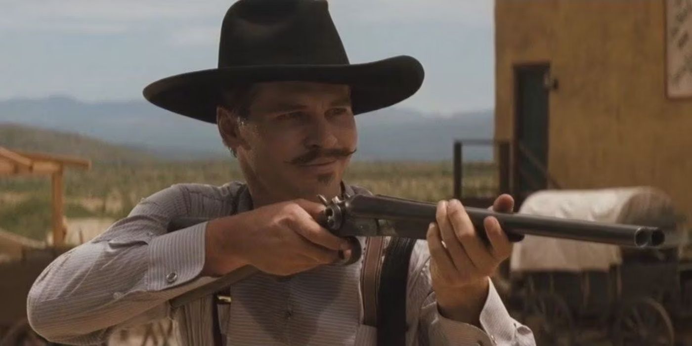 Doc Holliday smiling with his gun raised in Tombstone